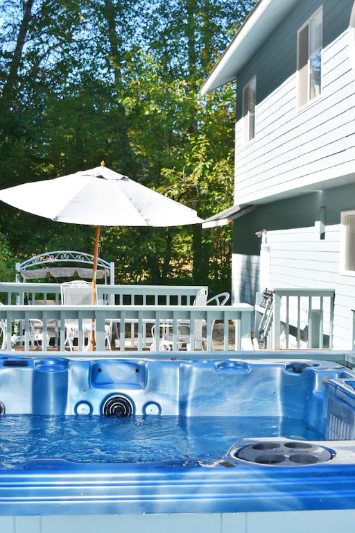 A hot tub in the middle of a deck.