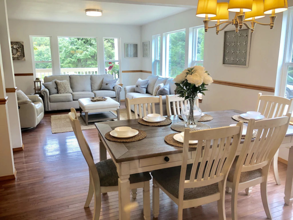 A dining room table with chairs and plates on it.