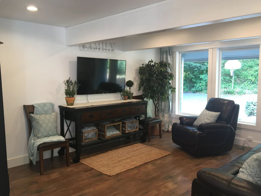 A living room with hardwood floors and a television.