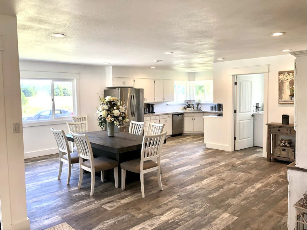 A large open kitchen with white chairs and table.