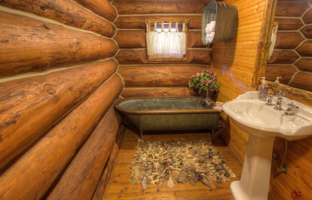 A bathroom with wood floors and walls.
